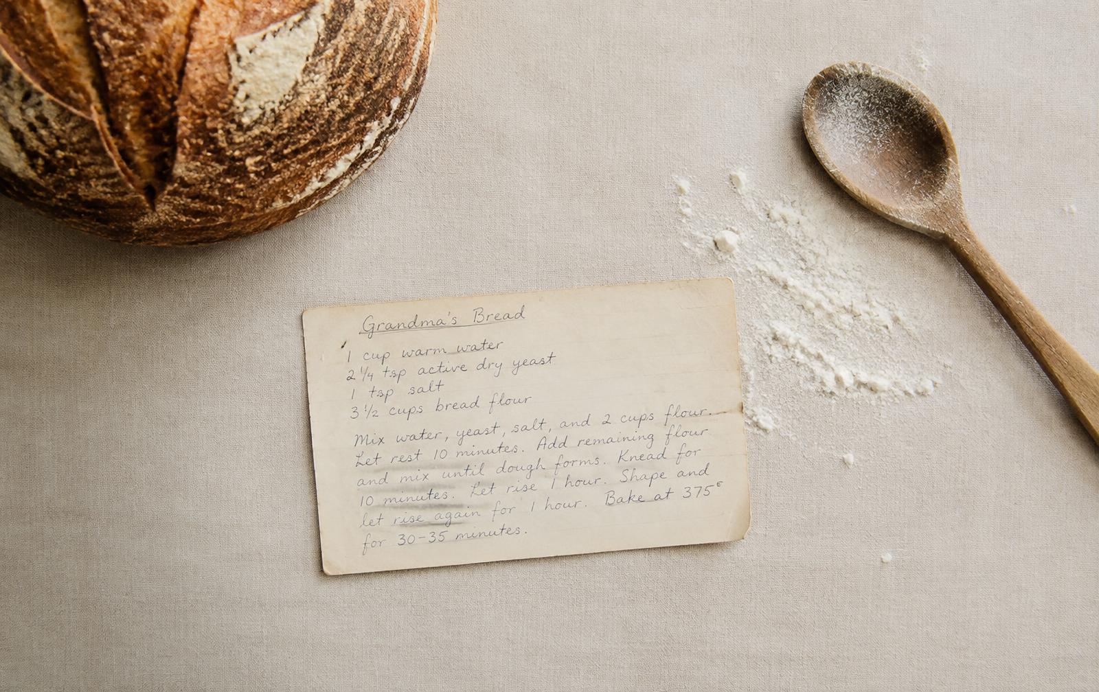 Handwritten family bread recipe card beside a fresh loaf